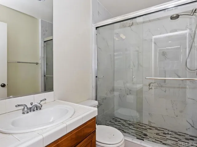 This downstairs bathroom is adjacent to small downstairs bedroom & desk off kitchen.