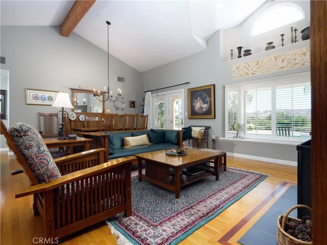 Large formal living room & dining room with hardwood floors, and vaulted ceilings.