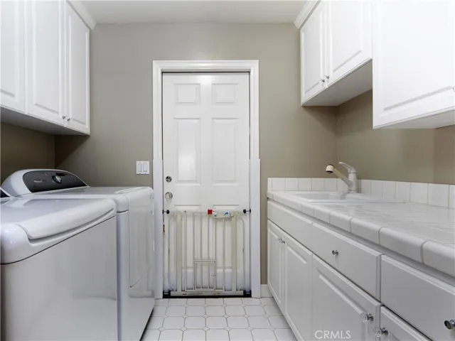 Laundry rm, with sink and plenty of storage.