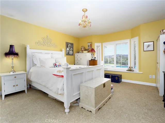 Large bedroom with window seat, and a view of the pool and canyons.