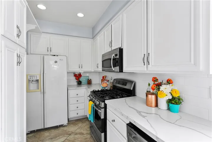 Loads of bright white cabinetry...including double door pantry.  Convenient access door to garage is just around the corner...