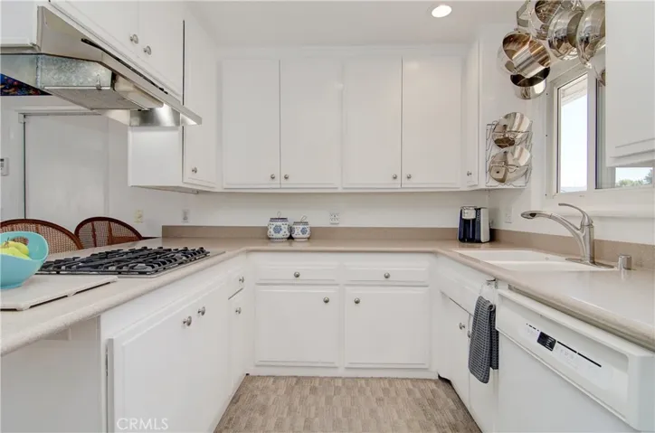 Bright white cabinetry, solid surface counters, recessed lighting and more help to create an enjoyable space...and every cook loves a window at the sink!