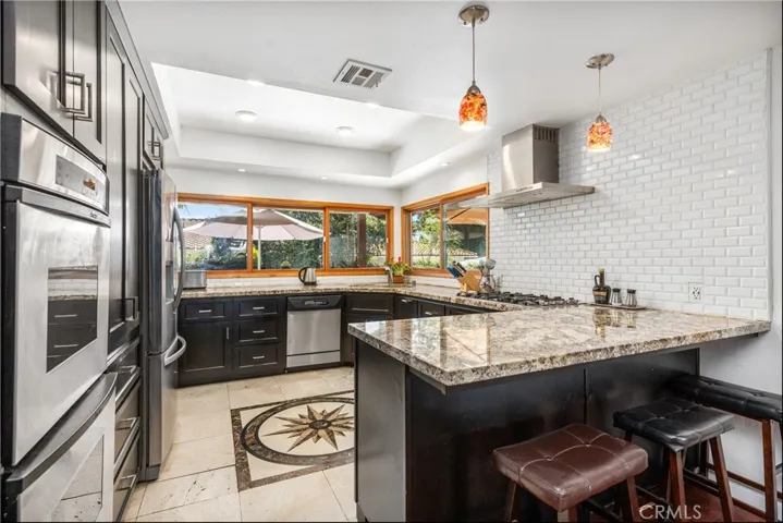 Kitchen with stainless steel appliances, granite counters, subway tile backsplash and custom cabinets with soft close drawers and doors.