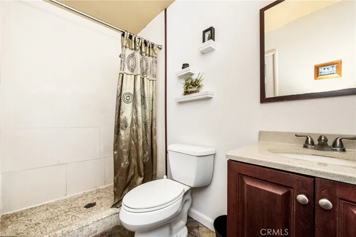 Full bath off the mud room and kitchen and with easy access to backyard. Limestone shower with slate floors and single sink.