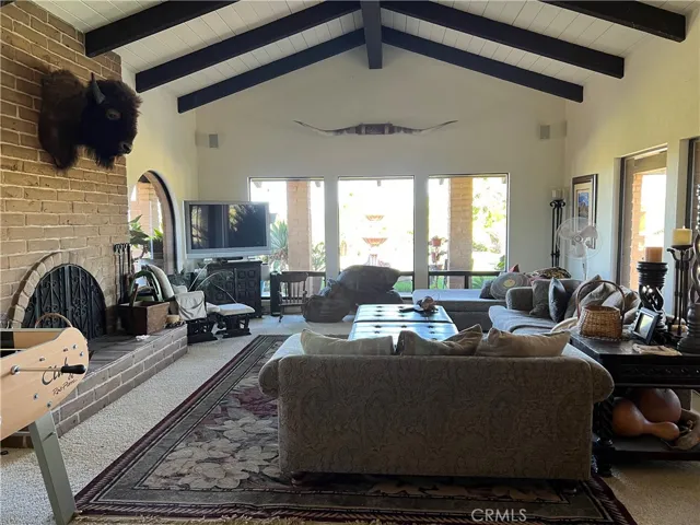 Beamed living room with wood burning fireplace.