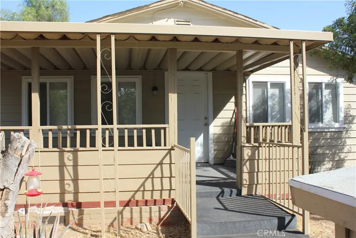 View of large front porch, entry door, newer windows