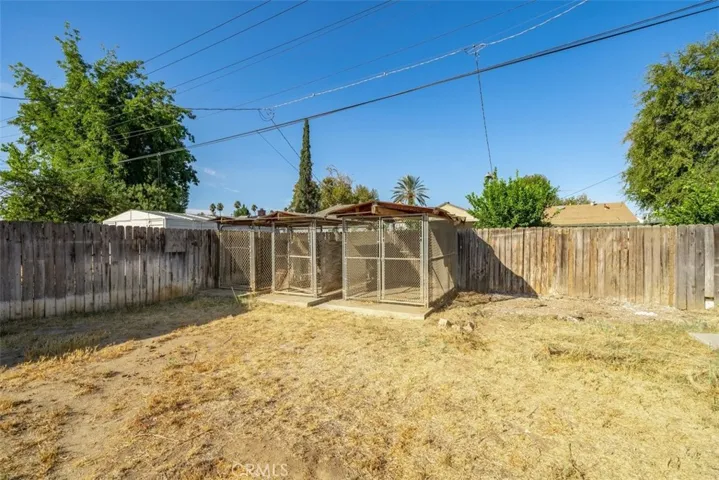 Corner of back yard showing 3 gated crates that could be removed.