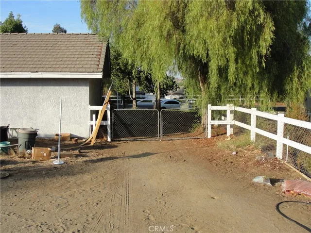 Side gate allows for easy access to rear yard and barn.  RV Access.