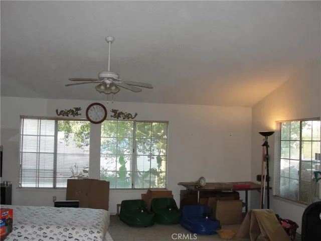 Large living room with 3 large windows, vaulted ceilings and ceiling fan