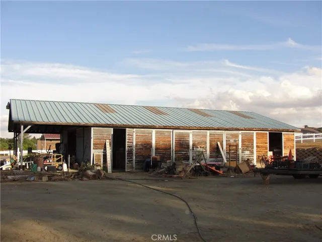 View of barn from side.  Metal roof with skylight type panels to allow extra light in barn.