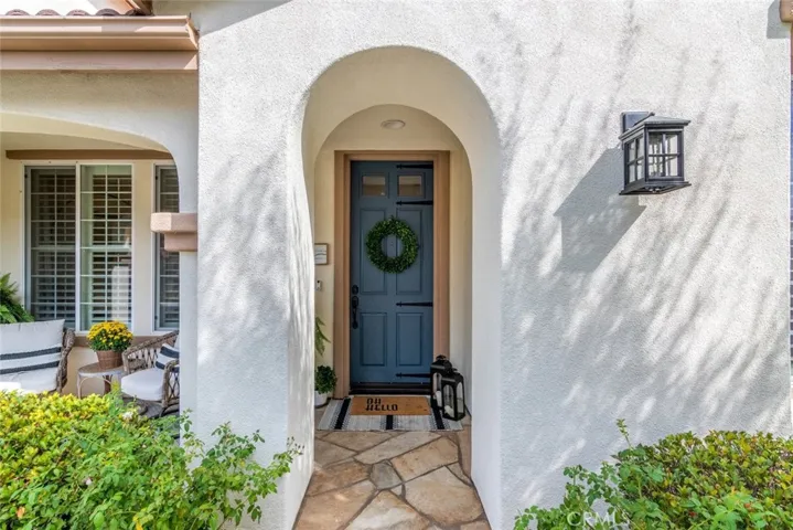 The flagstone walkway leads you through the thoughtful arch accent and blue door entry.