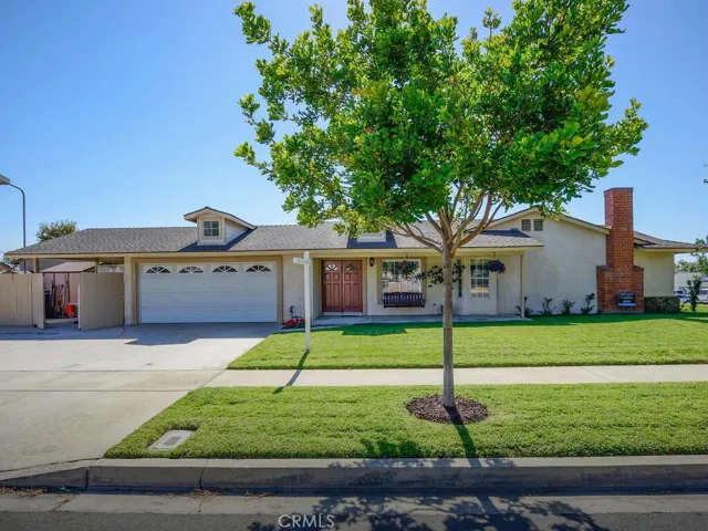 Front of home with double attached garage and covered, gated carport/RV parking