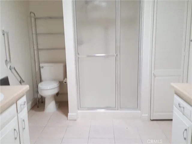 Bathroom shower with linen closet on the right, and his and her vanity.