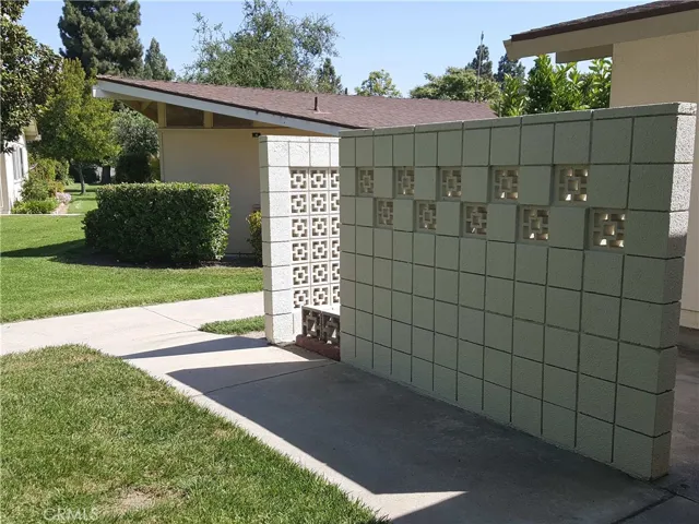 Entry area, front walled patio on the right. Laundry facility on the other side of side walk.