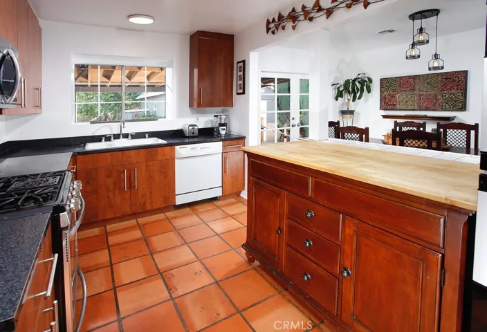 The cook in the family is going to truly appreciate the updated kitchen with its sparkling window, rich wood grained cabinetry, granite countertops, dual basin sink, self-cleaning stainless steel gas range and microwave oven, dishwasher, easy care terra cotta tiled floors and a handy breakfast bar.
