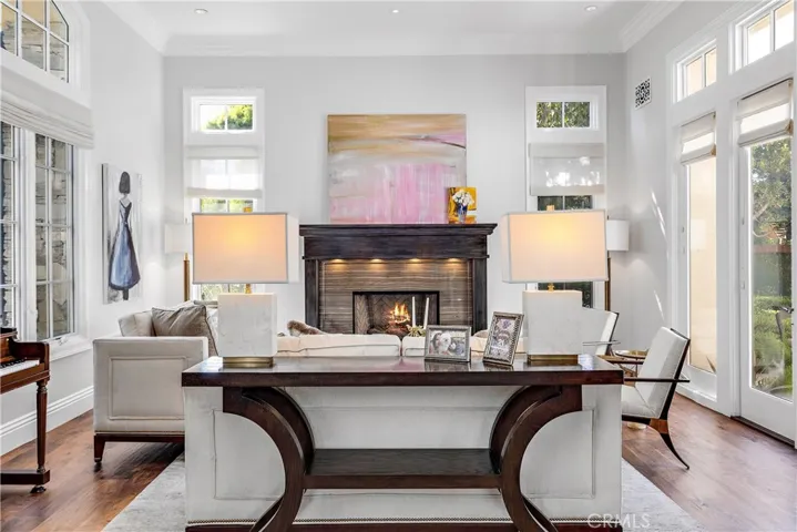 Formal living room with marble fireplace and wood mantle, french doors to reflection pool and water feature.