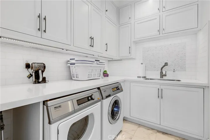 Laundry with utility sink, lots of cabinets.  Miele heavy duty washer and dryer.  Laundry shoot added from the master bedroom suite.