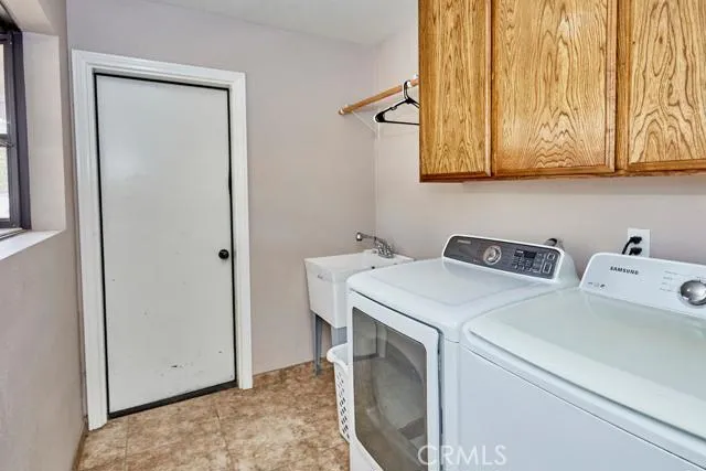 Indoor laundry is spacious and offers overflow storage space just off the kitchen.