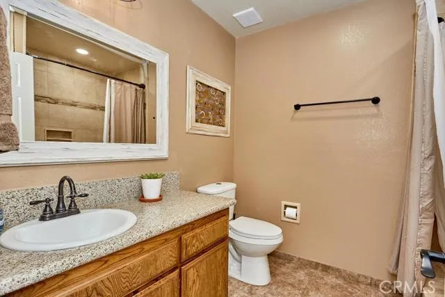 Hall bathroom is also remodeled with hranite, bronze fixtures, shower tile, and tile floors.