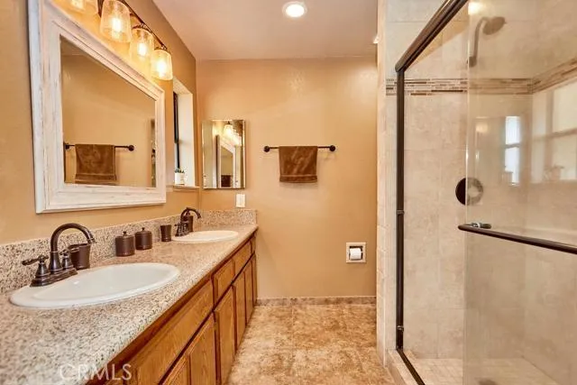 Remodeled master bathroom suite features a modern tile shower stall with oil rubbed bronze fixtures. Lighting in three fixtures throughout the space. Smart home exhaust fan, super quiet model with night light feature and Bluetooth music connectivity. Show