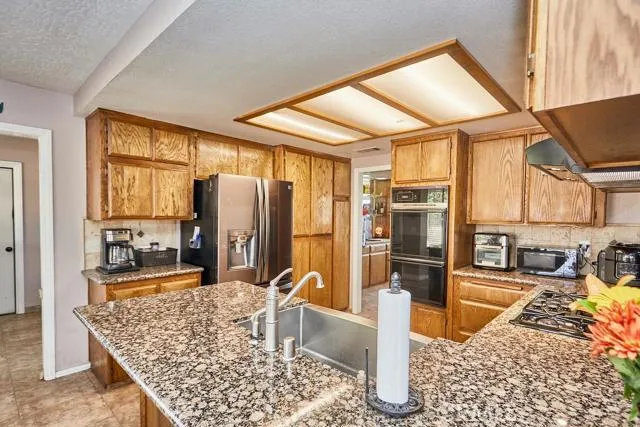Kitchen with granite counters, stainless steel farmhouse style apron sink. Tumbled stone backsplash. Dishwasher is 6 months old and has bluetooth connection.