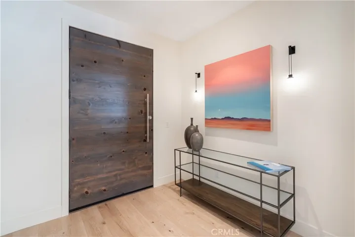 Custom wood front door at the entry with a large closet.