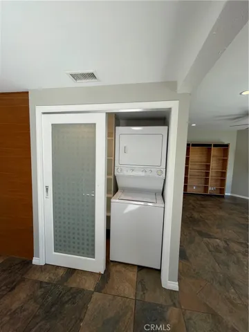 Stackable laundry in its own individual closet in the kitchen.