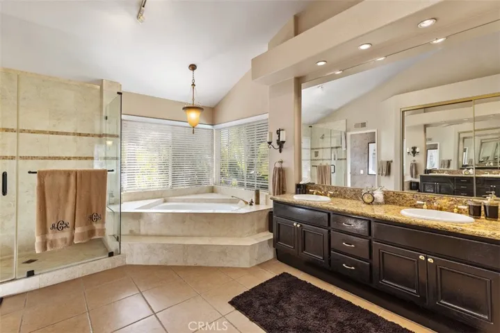 Master bath with dual sinks, privacy toilet door, separate tub and shower