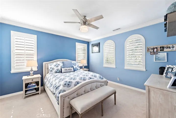 Bedroom 3 with private bath and plantation shutters, crown molding and ceiling fan