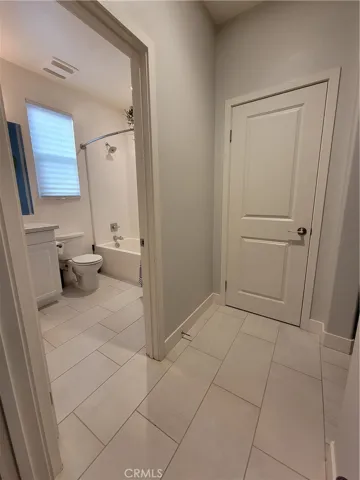 Full bathroom with walk in closet outside door.