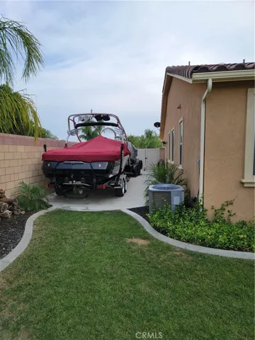 Boat on side of yard out of view of BBQ lounge area.