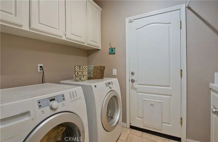 Laundry room has plenty of storage and a sink