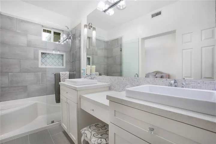 Master with dual shaker style vanities, walk in shower and designer lighting