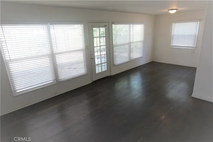 Living Room with refinished hardwood floors and Wall of Windows to patio &  fenced back yard