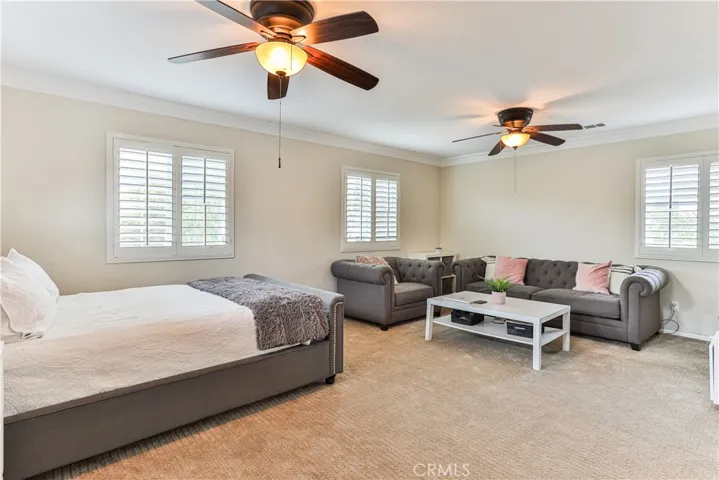 Space features dual lighted ceiling fans, crown molding and shutters