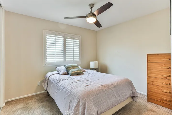 Bedroom #4 features lighted ceiling fan, shutters and mirrored closet door.