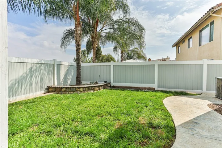 Low maintenance grassy area is just enough space for kids and fur babies alike