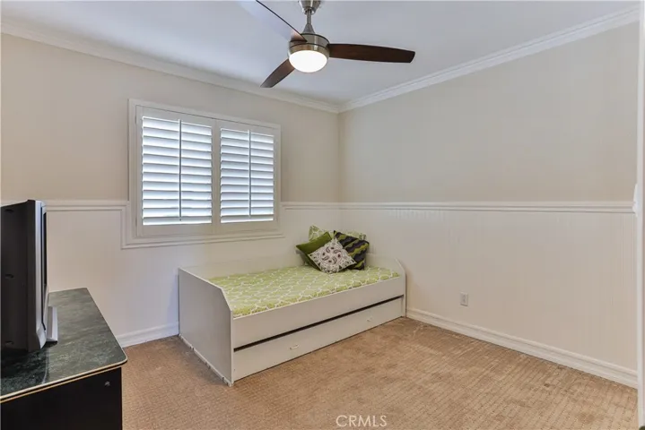 Bedroom #5 has wainscoting bead board, lighted ceiling fan and shutters.