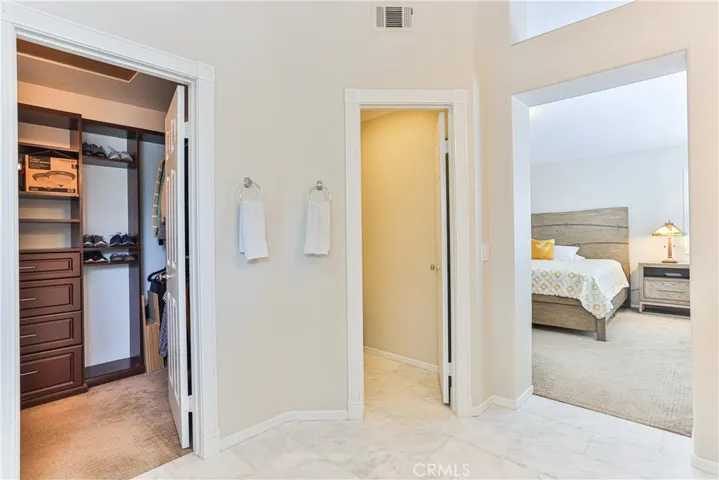 The walk in closet is spacious with custom storage and a privacy door to the toilet