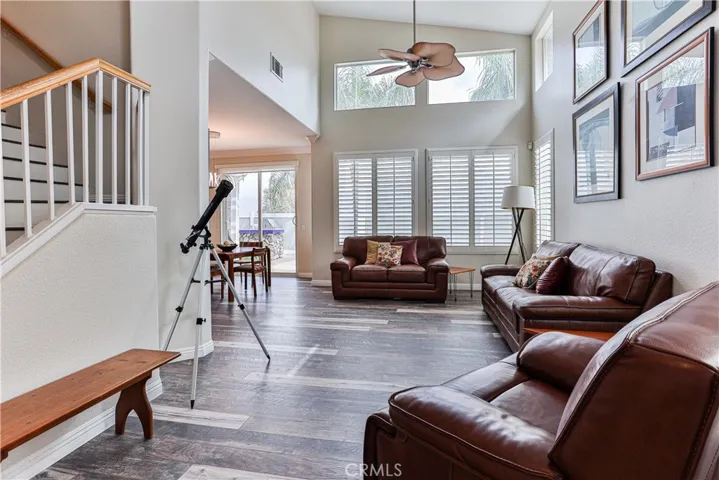 Spacious formal living room with vaulted ceilings, laminate flooring throughout and 2 ceiling fans.