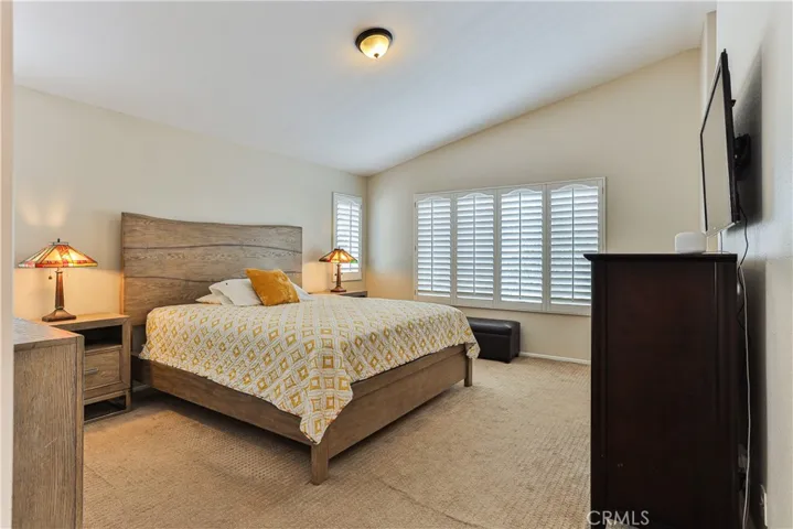 Master bedroom features vaulted ceilings & shutters