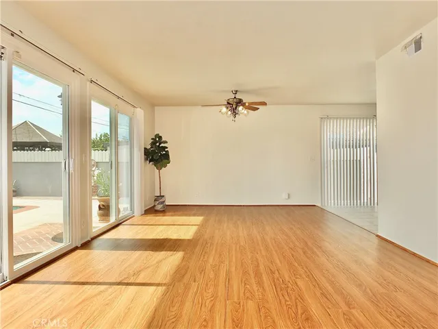 Living room flipped perspective leading to kitchen, bar, and garage-converted family room.