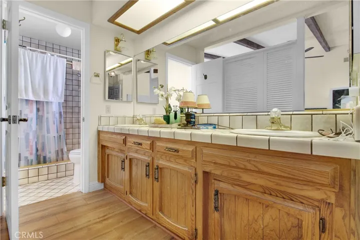Master bath features a tiled walk in shower, his and her sinks, new laminate flooring, large mirror and medicine cabinet