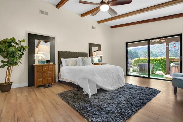 Private master bedroom w/ new laminate flooring, beam ceilings and a fan. Convenient sliding door to the outside covered patio