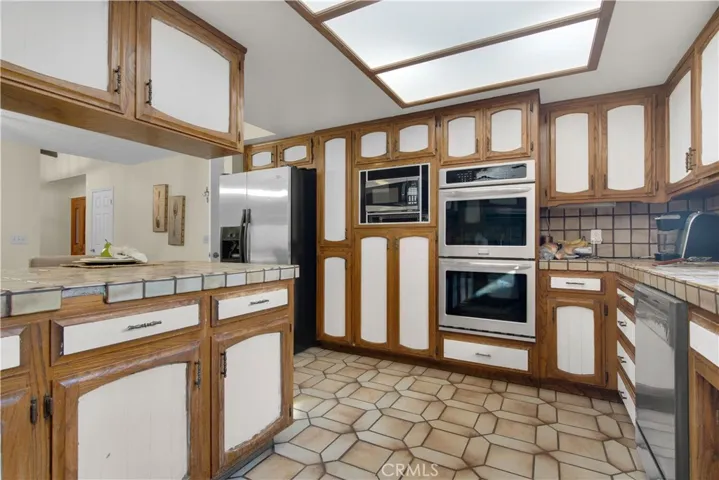 Double oven, built-in microwave, cooktop, hood,  and stainless refrigerator