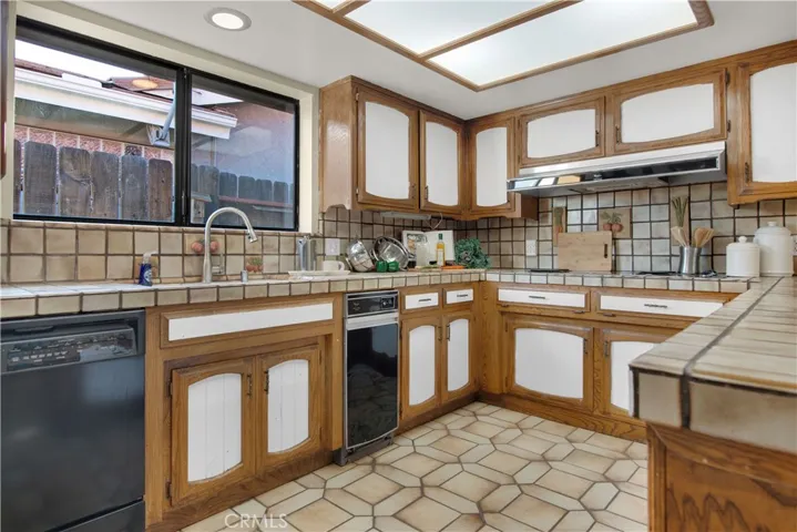 Spacious kitchen with lots of cabinets, tile flooring and countertops