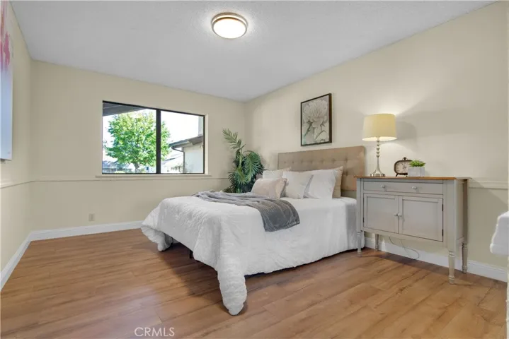 Bedroom features new laminate flooring and mirrored closet doors