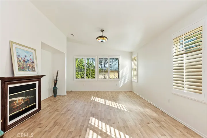 FAMILY ROOM OFF KITCHEN WITH LAMINATE FLOORING, COZY FIREPLACE AND DOOR TO BACK YARD AREA