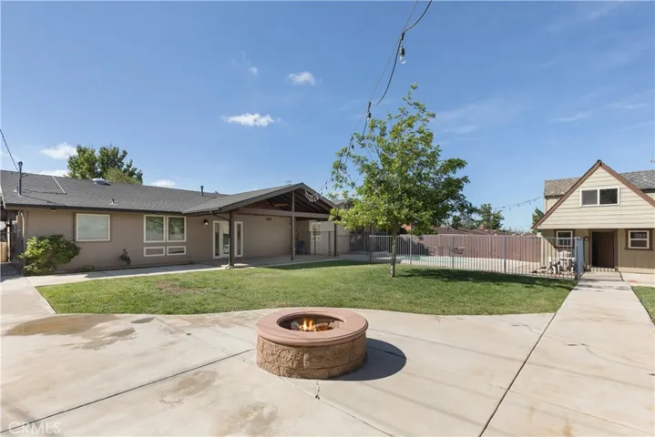 Full view of this grand backyard with firepit to enjoy during a clear evening