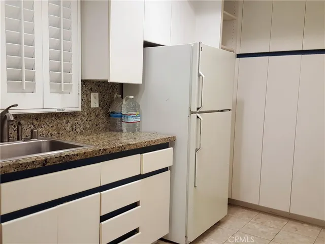Stainless sink under plantation shutter covered window.